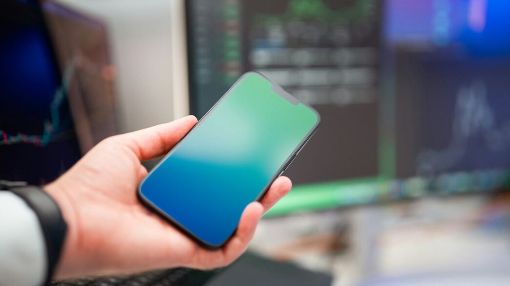 a person holding a cell phone in their hand