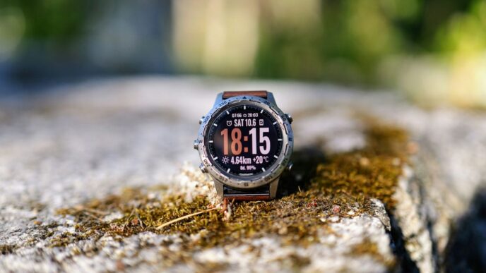 A smartwatch displays the time on a mossy surface.
