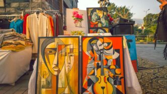 Art is displayed at an outdoor market.