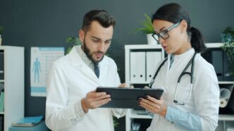 Two doctors looking at a tablet together