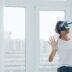 Woman using virtual reality headset indoors near window