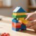 Hands stacking colourful blocks to build a business.