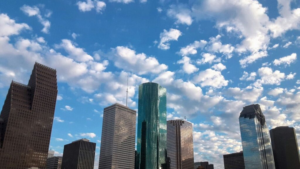 a view of a city with skyscrapers and clouds in the sky