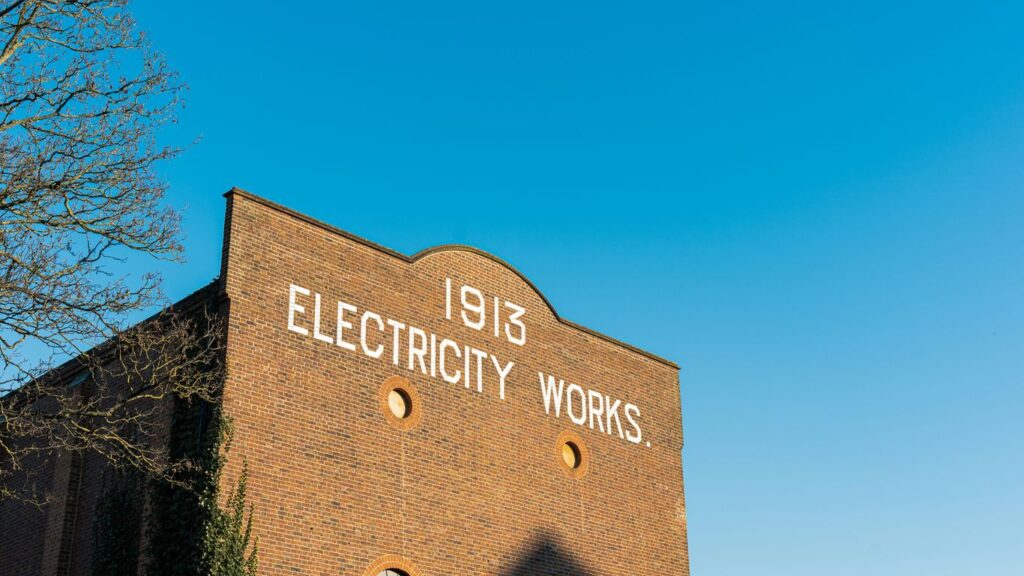 A brick building with a sign that says electricity works