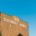 A brick building with a sign that says electricity works