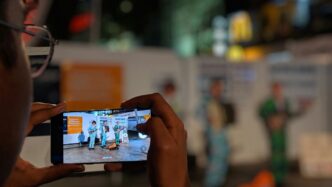 person holding black smartphone taking photo of people performing