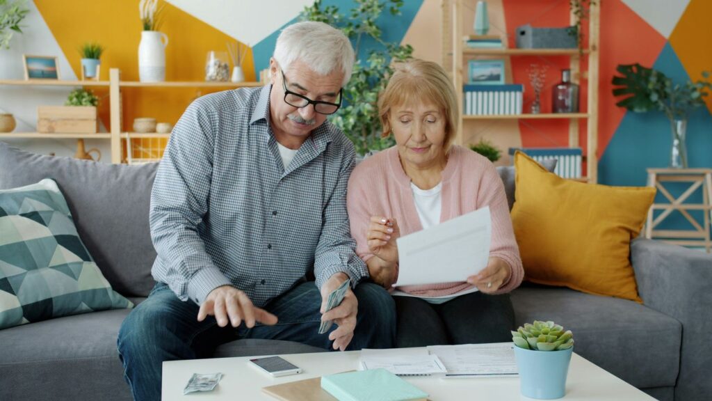 Elderly couple reviewing documents at home