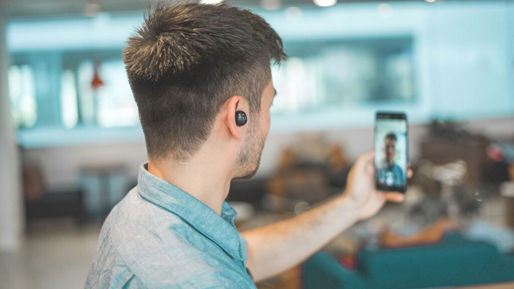 shallow focus photo of man in gray collared top taking selfie