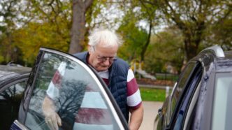 Elderly man getting into a car