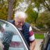 Elderly man getting into a car