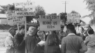 Protesters hold signs supporting unionism and demanding a contract.
