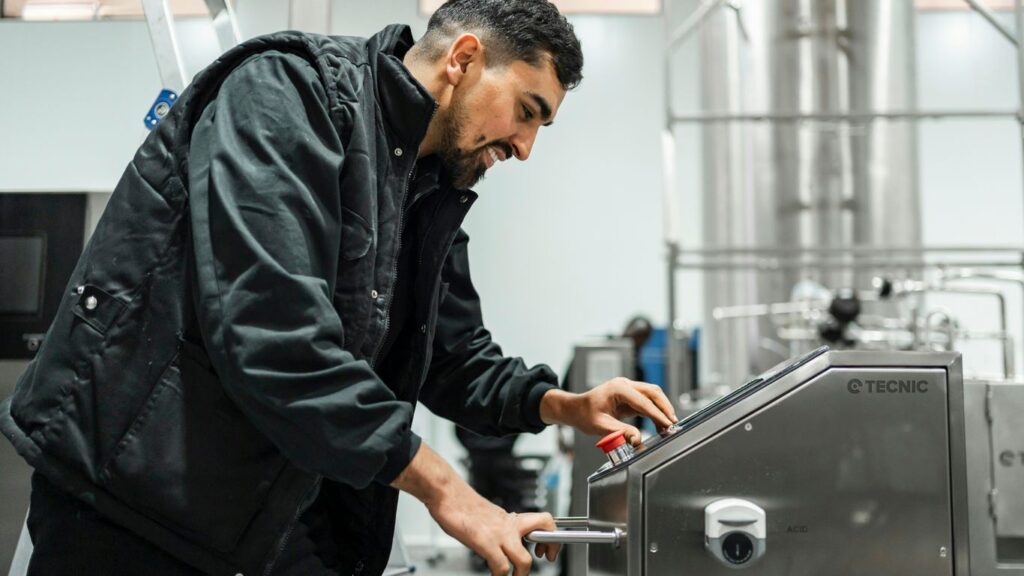 A man operates equipment in an industrial setting.