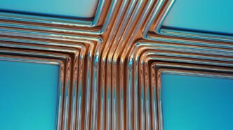 Copper pipes forming a cross shape on blue background