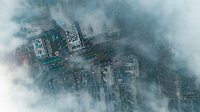 Aerial view of buildings partially covered by clouds
