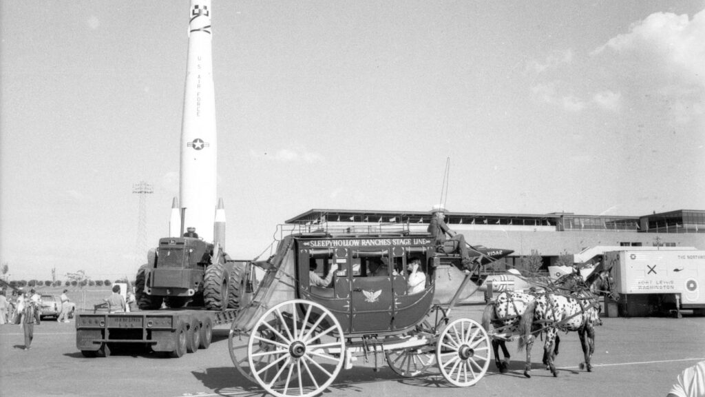 grayscale photo of people riding on carriage