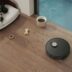 Robot vacuum cleaning a wooden floor near a dog bed