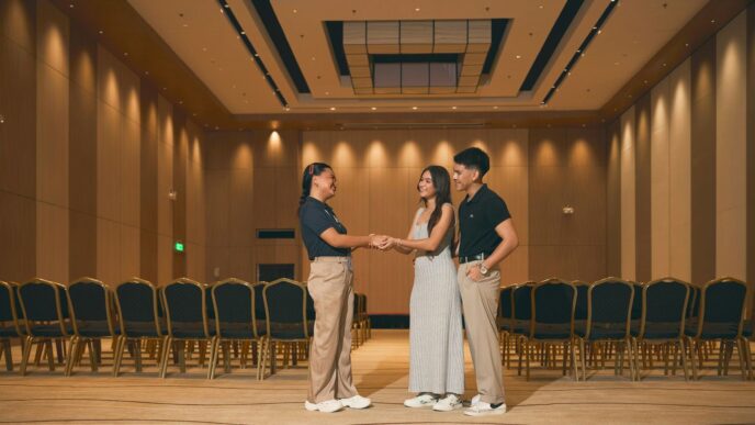 Three people standing in an empty conference room.