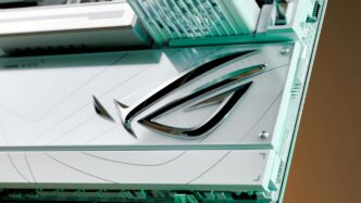 Close-up of a chrome logo on a white surface.