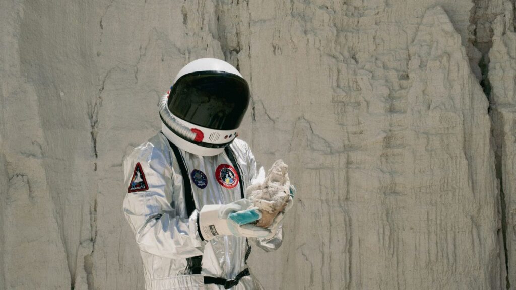 a man in a space suit holding something in his hands