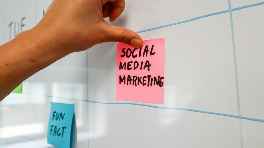 a hand is writing on a sticky note