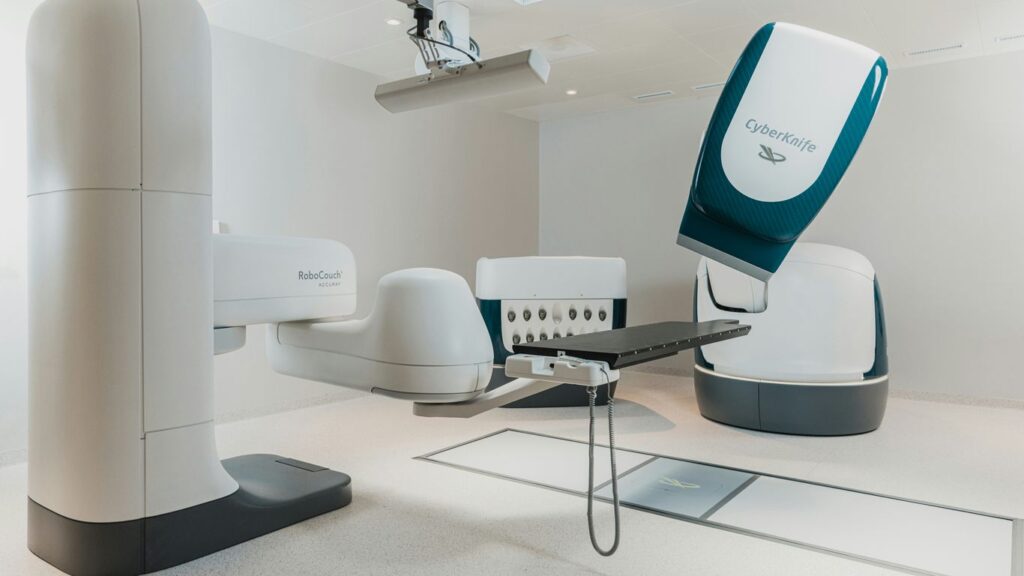 a room with a chair and a table with a computer on it