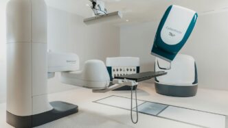 a room with a chair and a table with a computer on it