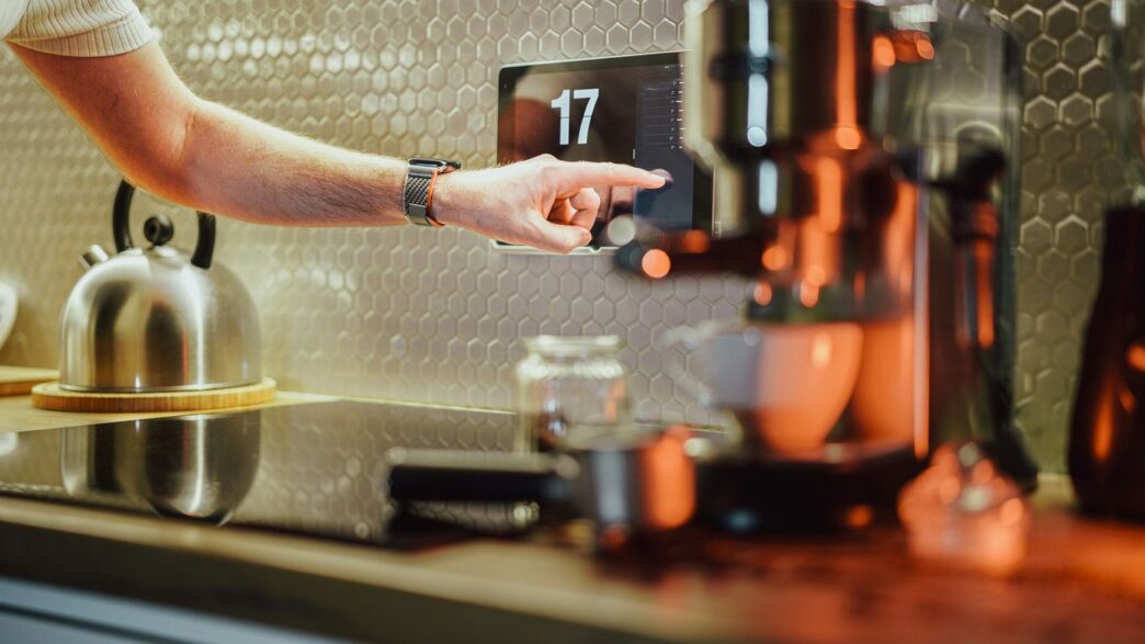 a person pressing a button on a coffee machine