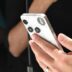 Person holding a white smartphone with a camera lens