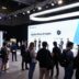 Futuristic tech conference with diverse attendees and innovative displays.