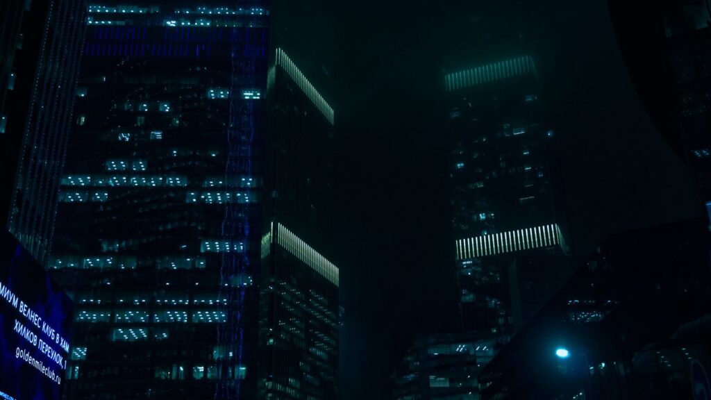 Dark skyscrapers light up the night sky.