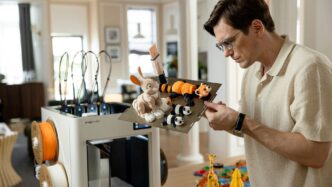 Man working with 3D printer and toys