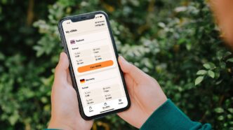 Person holding a smartphone with currency exchange app