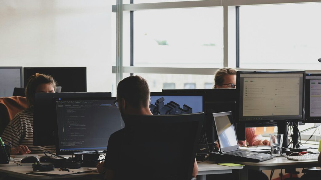 people sitting on chairs and using computers