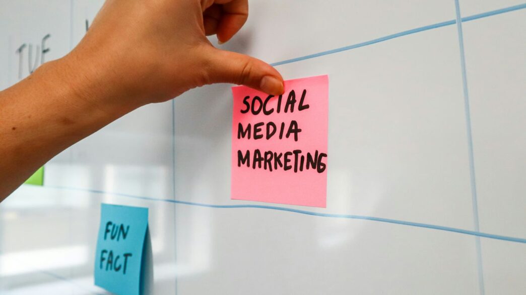 a hand is writing on a sticky note