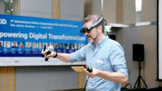 man in blue and white plaid button up shirt holding black and brown corded microphone