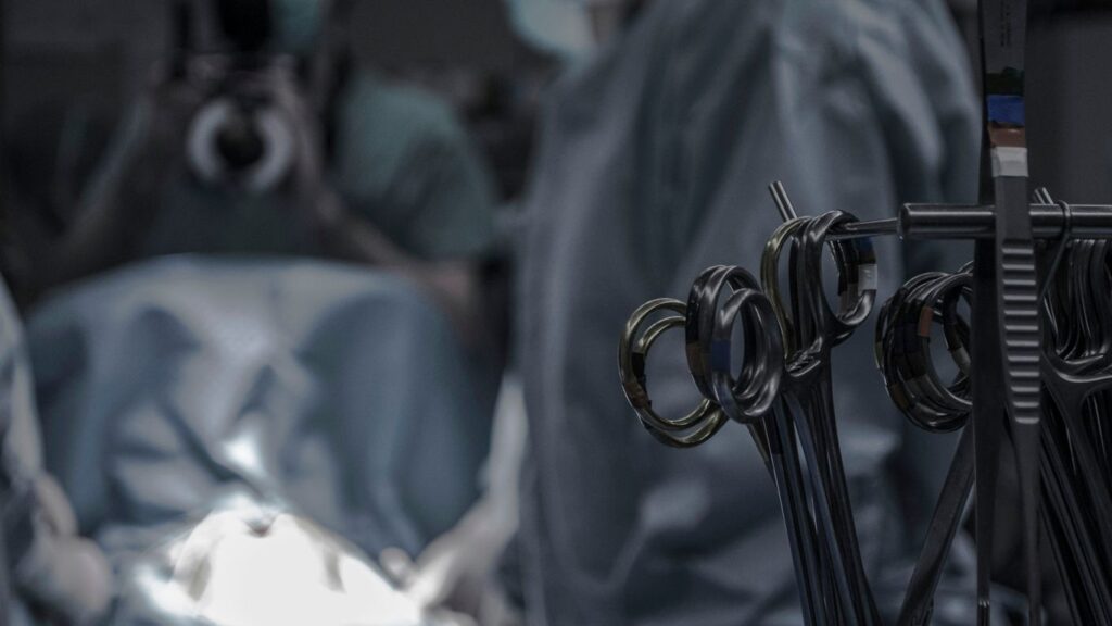 gray surgical scissors near doctors in operating room