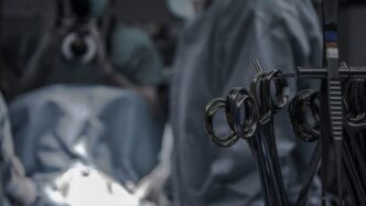 gray surgical scissors near doctors in operating room