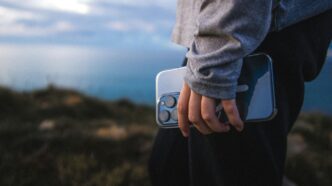 Person holding a smartphone on a scenic overlook
