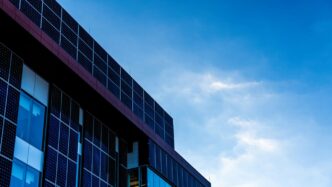 Modern building facade with solar panels against blue sky