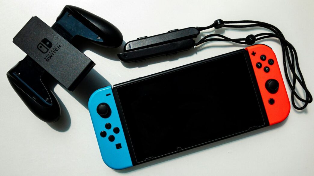white nintendo switch beside black usb flash drive