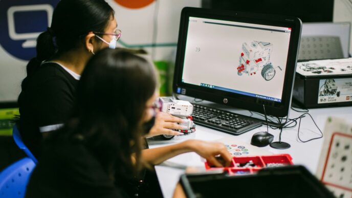 a couple of women sitting at a table with a laptop