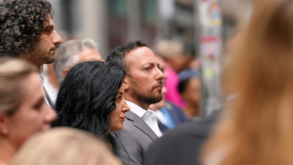 People gathered outdoors, looking attentively