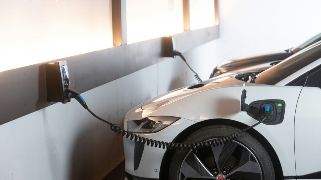 White electric car charging at a station.