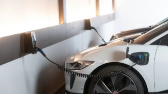 White electric car charging at a station.