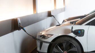 White electric car charging at a station.