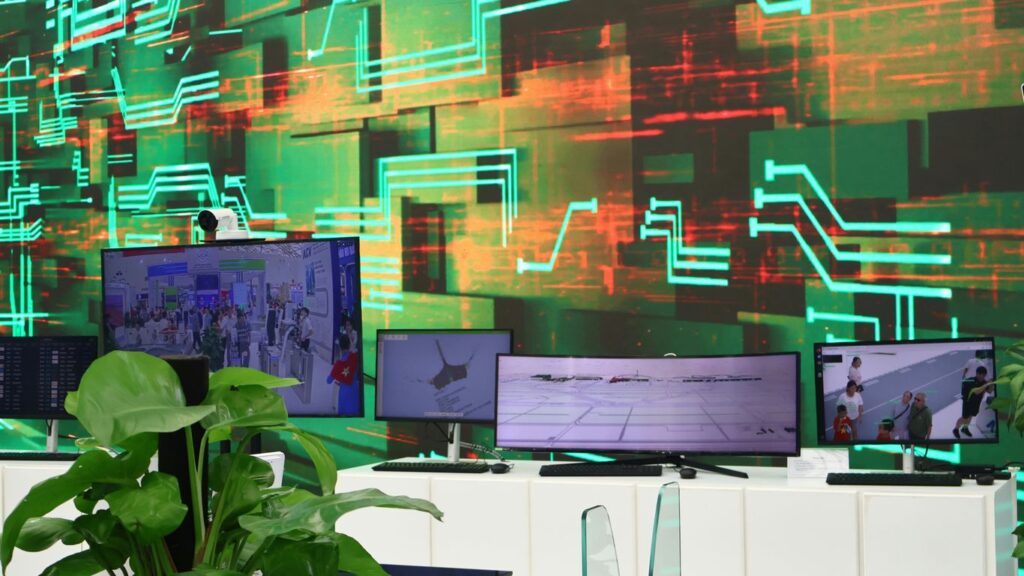 Digital screens display data on a circuit board background