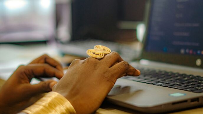 Hands typing on a laptop with gold jewelry