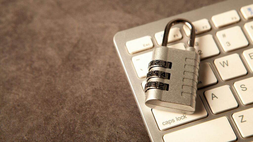 A padlock rests on a computer keyboard.