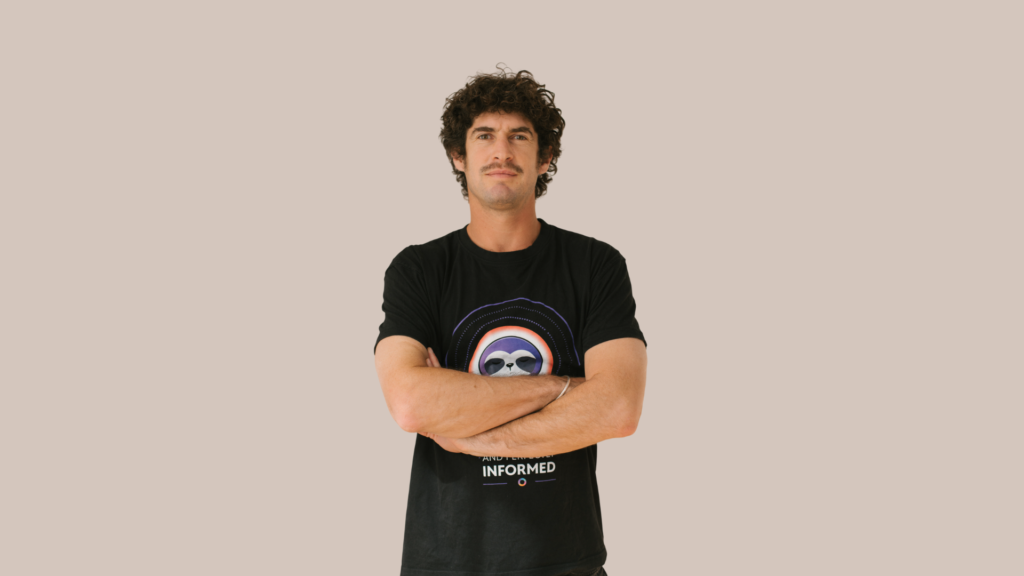 man posing in front of cream wall
