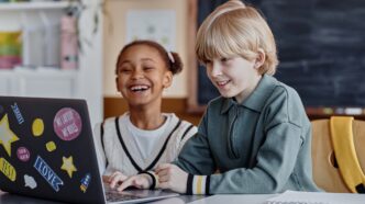 two children using a laptop